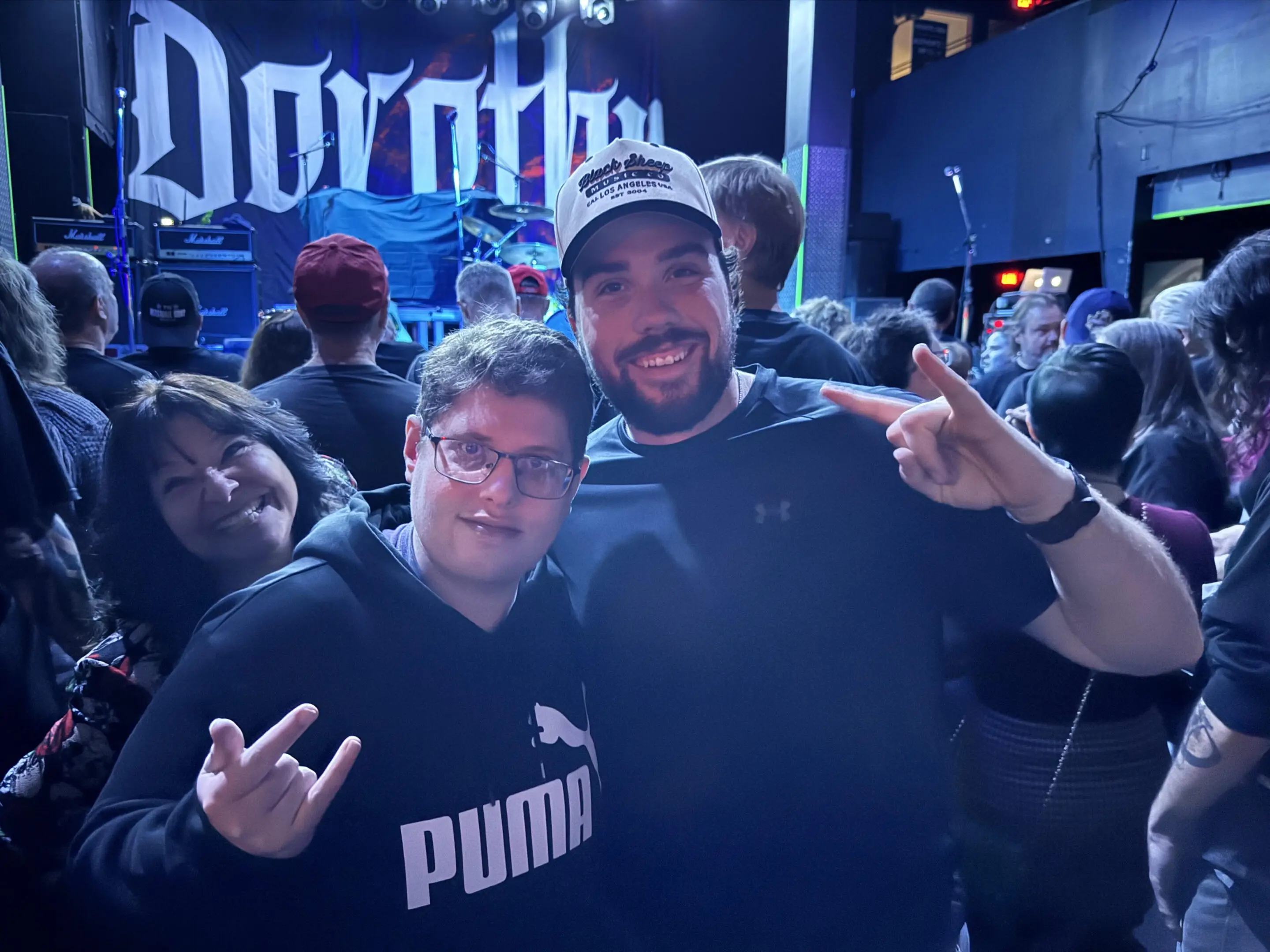 People posing at a rock concert event.
