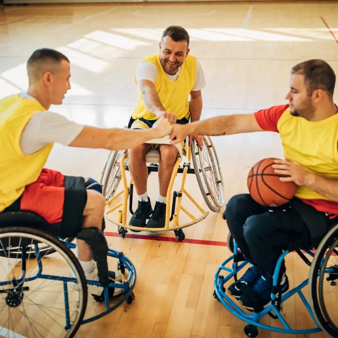Wheelchair basketball players fist-bumping on court.