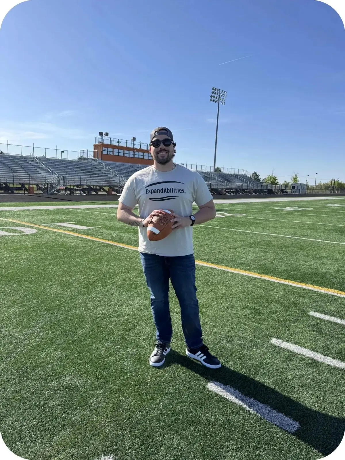 Man holding football on outdoor field.
